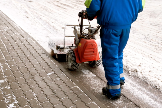 Man working with a snow blowing machine